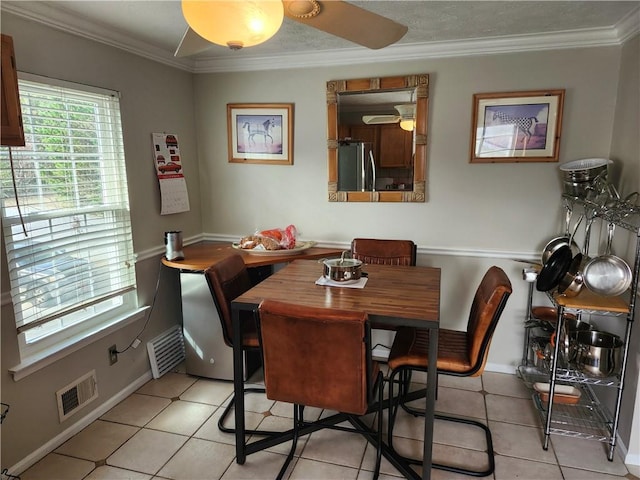 dining room featuring crown molding and light tile patterned floors