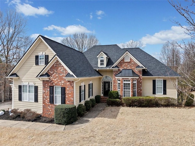 view of front of home featuring brick siding and a shingled roof