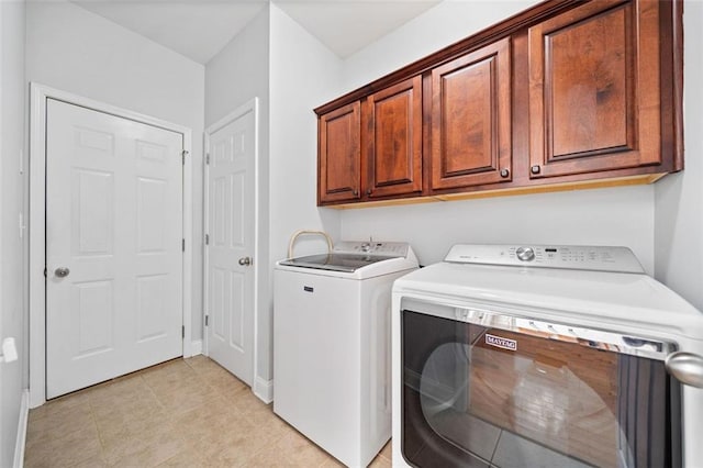 laundry area with cabinet space, light tile patterned floors, and washing machine and dryer