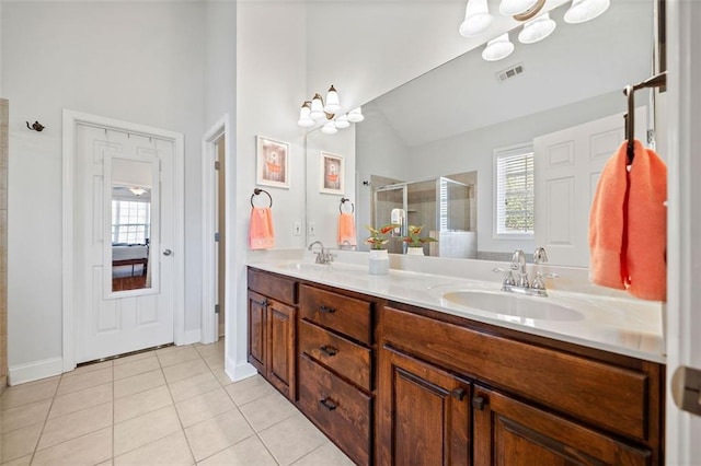 bathroom with a sink, double vanity, a stall shower, and tile patterned floors