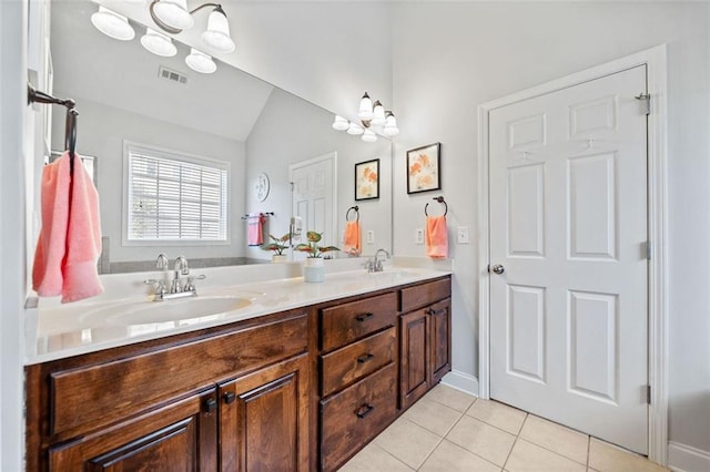 bathroom featuring tile patterned floors, visible vents, a sink, double vanity, and vaulted ceiling