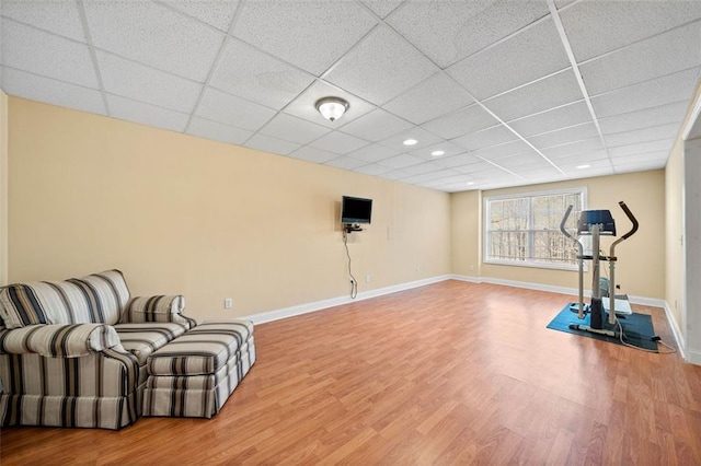 workout room with a drop ceiling, recessed lighting, baseboards, and wood finished floors