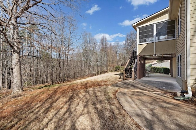 view of yard with a view of trees and stairs