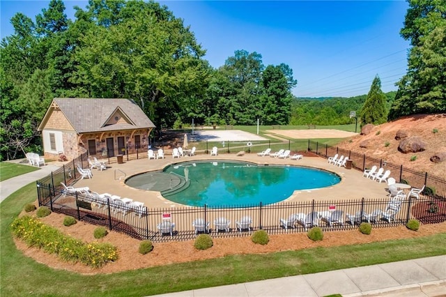 pool featuring a patio area, an outbuilding, and fence