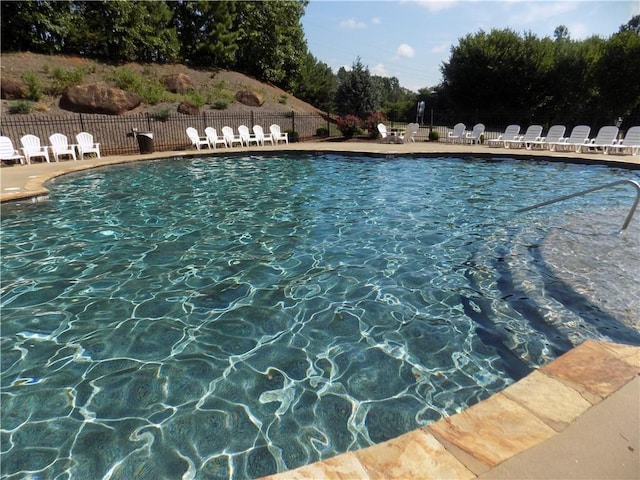 pool with a patio and fence