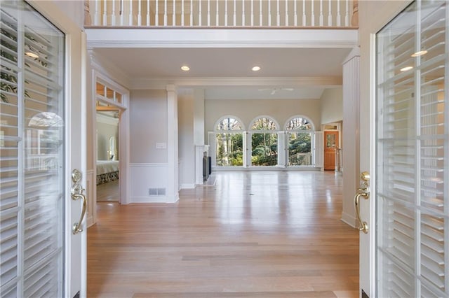 foyer with baseboards, visible vents, crown molding, light wood-style floors, and recessed lighting