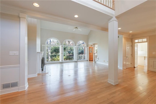 unfurnished living room featuring light wood finished floors, visible vents, ceiling fan, ornate columns, and a fireplace