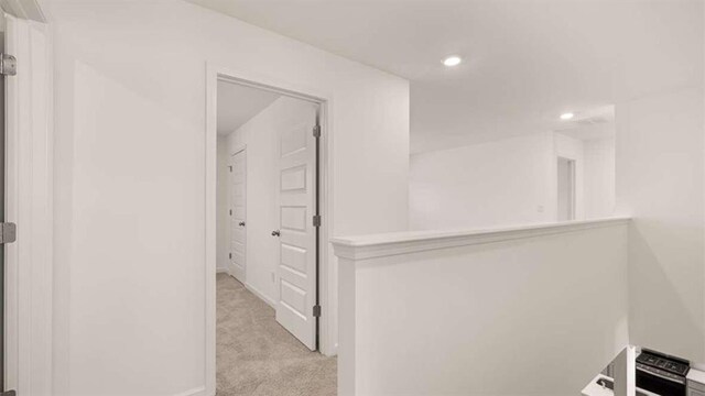 hallway featuring light colored carpet