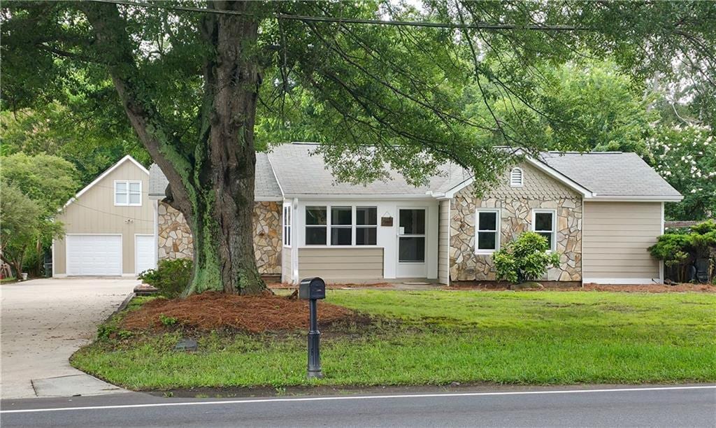 6109 N Main St SE, Acworth, GA 30101 - single story home with stone siding, a detached garage, a front yard, and a shingled roof