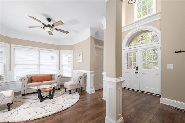 entrance foyer featuring decorative columns, plenty of natural light, and dark hardwood / wood-style floors