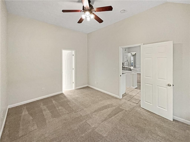 unfurnished room featuring light colored carpet, sink, vaulted ceiling, and ceiling fan