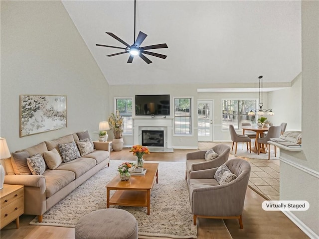 living room featuring high vaulted ceiling, light wood-type flooring, and ceiling fan