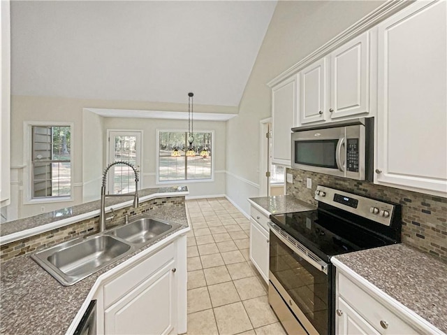 kitchen with decorative backsplash, sink, vaulted ceiling, white cabinetry, and appliances with stainless steel finishes