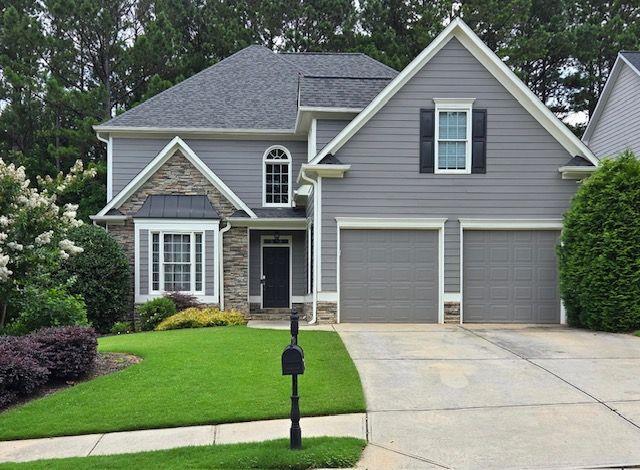 595 Bentleaf Dr, Dallas, GA 30132 - view of front of property featuring stone siding, driveway, a front lawn, a garage, and a shingled roof