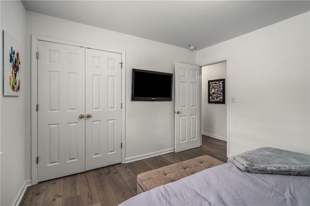 bedroom with dark hardwood / wood-style floors and a closet