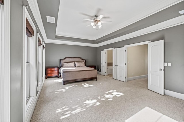 unfurnished bedroom with ceiling fan, light colored carpet, crown molding, and a tray ceiling