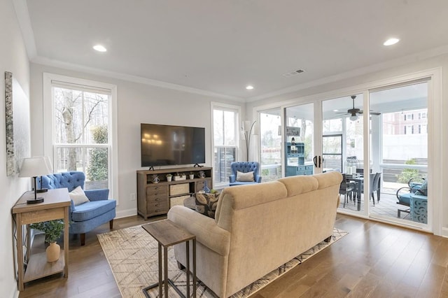 living area featuring recessed lighting, visible vents, baseboards, ornamental molding, and dark wood-style floors