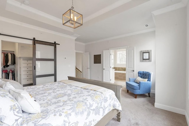 bedroom with a walk in closet, crown molding, light colored carpet, a barn door, and baseboards