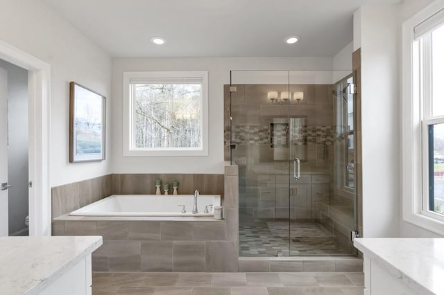 bathroom with a garden tub, recessed lighting, toilet, vanity, and a shower stall