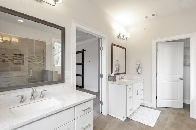 bathroom featuring a shower stall, visible vents, two vanities, and a sink