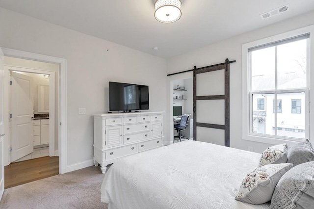 bedroom with carpet floors, a barn door, multiple windows, and visible vents