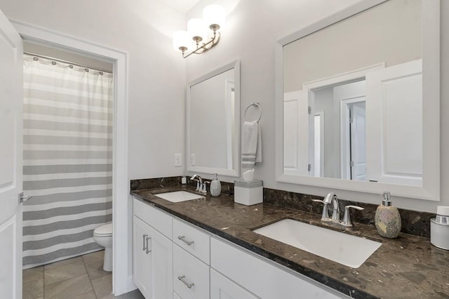 bathroom featuring toilet, double vanity, and a sink