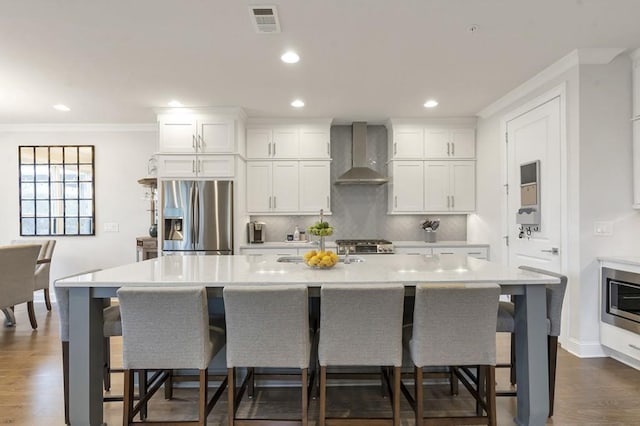 kitchen featuring stainless steel fridge with ice dispenser, light countertops, visible vents, decorative backsplash, and wall chimney exhaust hood