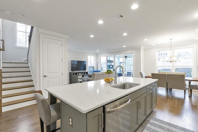 kitchen featuring a sink, crown molding, gray cabinets, and stainless steel dishwasher