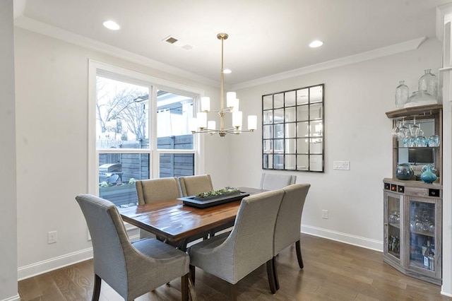 dining room with dark wood-style flooring, visible vents, an inviting chandelier, ornamental molding, and baseboards