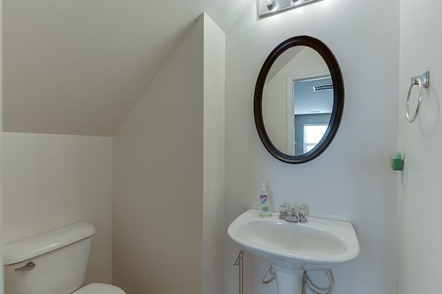 bathroom with toilet, visible vents, and a sink