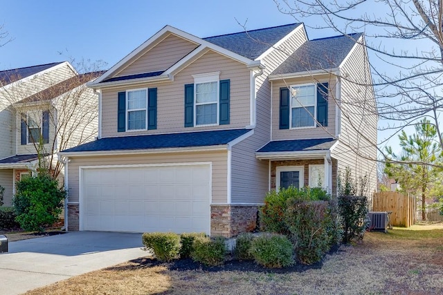 view of front facade with an attached garage, central AC, fence, stone siding, and driveway