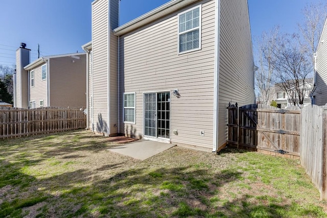 back of house with a chimney, fence, and a lawn