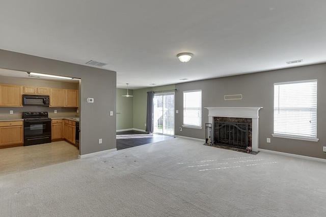 unfurnished living room featuring baseboards, a premium fireplace, visible vents, and light colored carpet