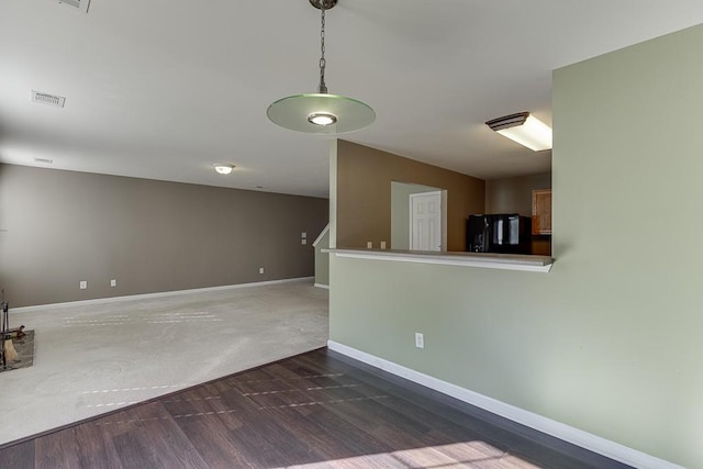 unfurnished room with visible vents, baseboards, and wood finished floors