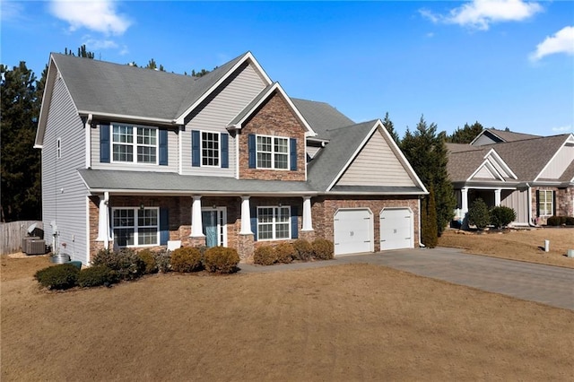 view of front of house featuring a garage, covered porch, a front lawn, and central air condition unit