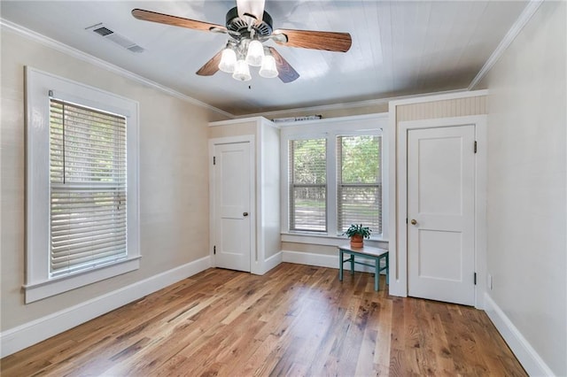 spare room with ceiling fan, ornamental molding, hardwood / wood-style floors, and a wealth of natural light