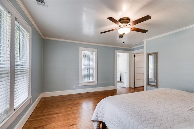 bedroom featuring crown molding, connected bathroom, hardwood / wood-style flooring, and ceiling fan