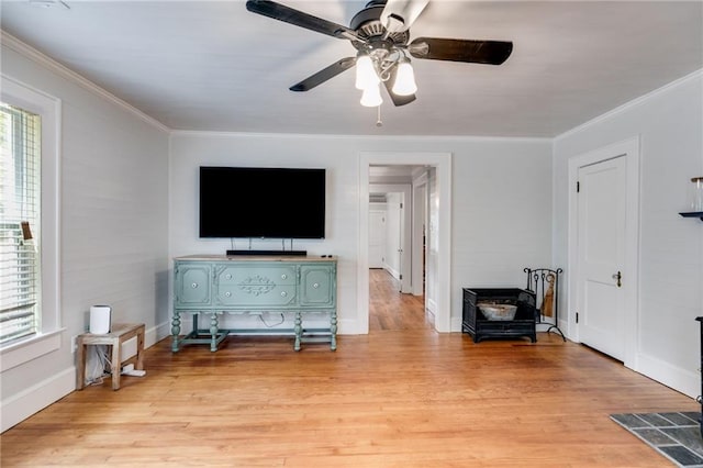 living room featuring light hardwood / wood-style floors, ornamental molding, and ceiling fan