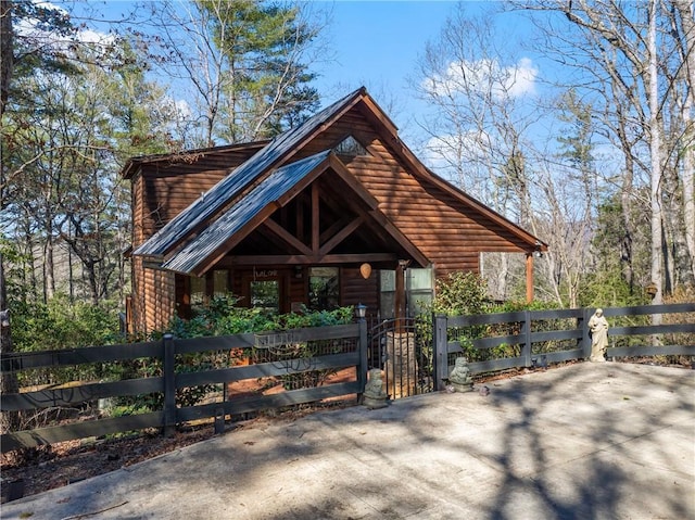 view of front of property with a fenced front yard and faux log siding