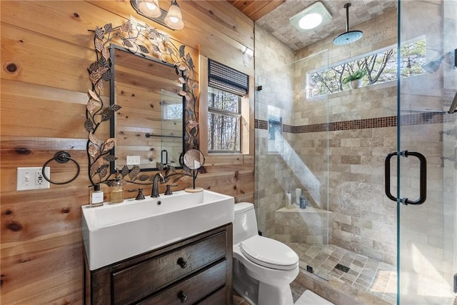 full bath featuring toilet, wood walls, vanity, and a stall shower