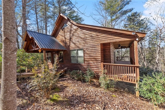 view of side of home featuring a ceiling fan, metal roof, and a porch