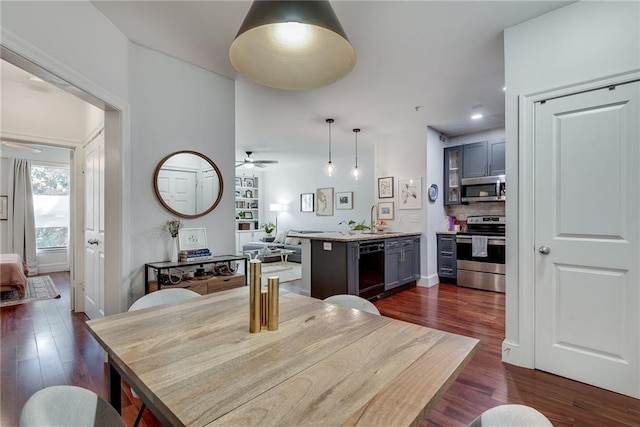 dining room with ceiling fan, dark hardwood / wood-style flooring, and sink