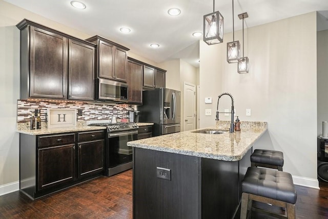 48 Ironwood Ct, Dallas, GA 30132 - kitchen with light stone counters, stainless steel appliances, a sink, dark wood-style floors, and tasteful backsplash