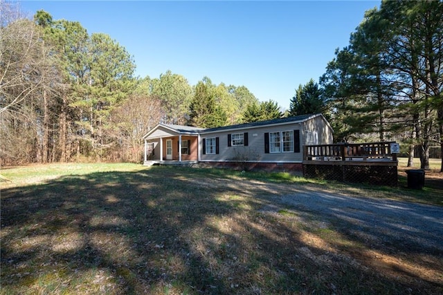 view of front of home featuring a deck, crawl space, and a front yard