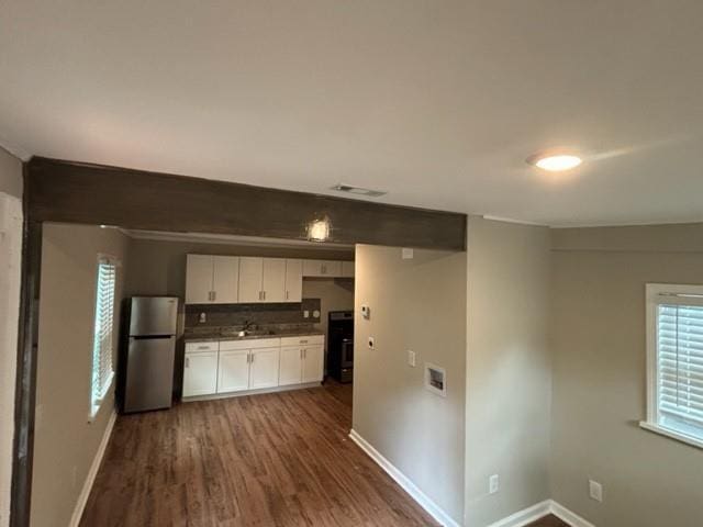 kitchen featuring dark hardwood / wood-style floors, stainless steel refrigerator, sink, white cabinets, and stove