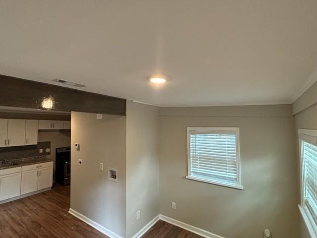 kitchen with range, white cabinets, and dark hardwood / wood-style flooring