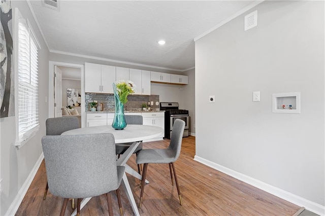 dining room featuring ornamental molding and light hardwood / wood-style flooring