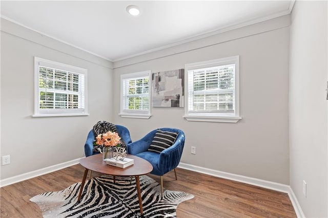 living area with ornamental molding and wood-type flooring