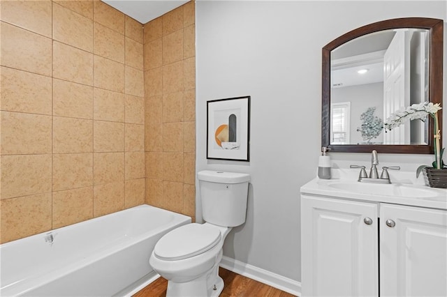 full bathroom with hardwood / wood-style flooring, vanity, tiled shower / bath, and toilet