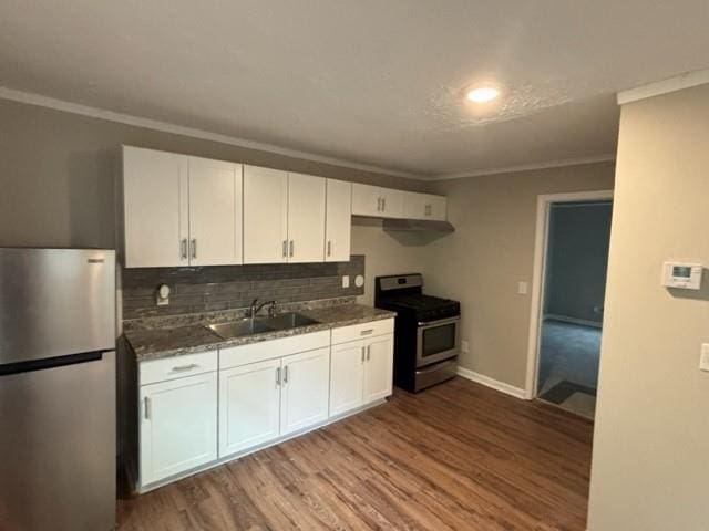 kitchen with white cabinetry, sink, stainless steel appliances, and hardwood / wood-style floors